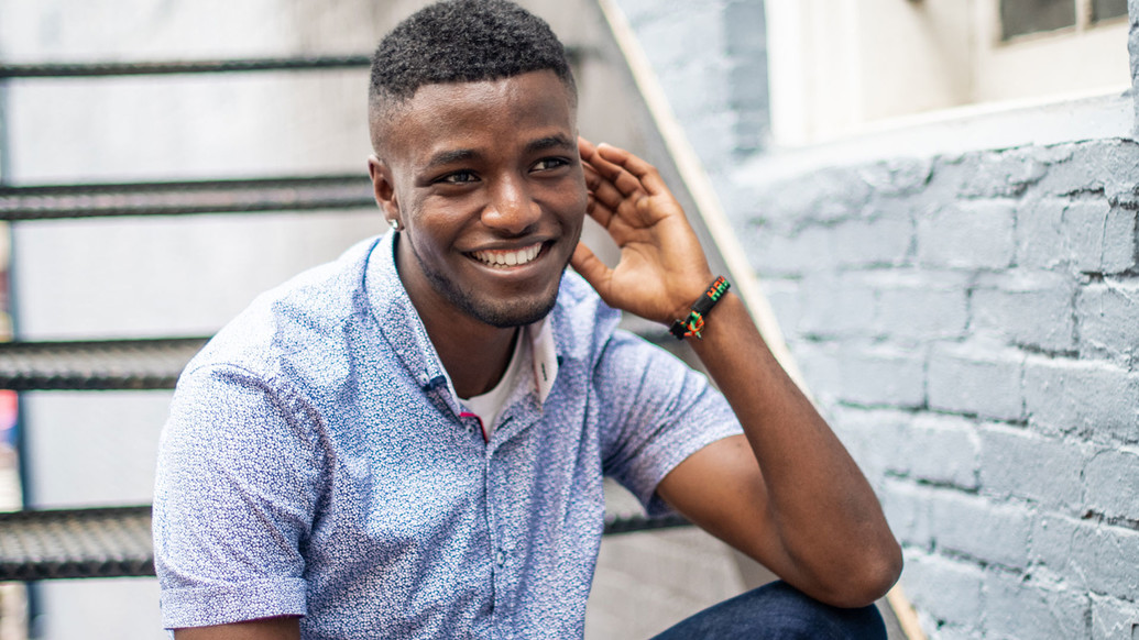 Closeup of a student, sitting on steps, smiling