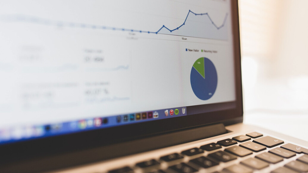 Close up of a laptop screen featuring charts and graphs