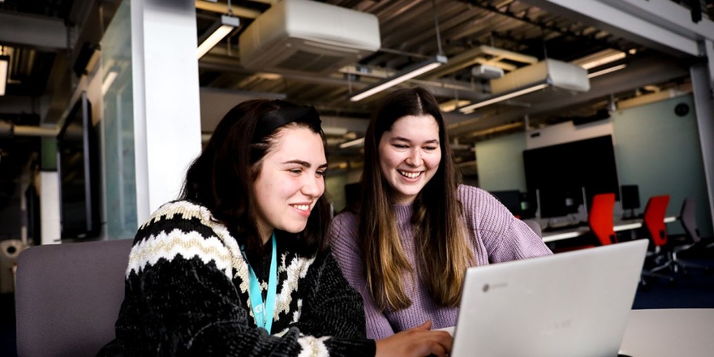 Two students looking at a laptop
